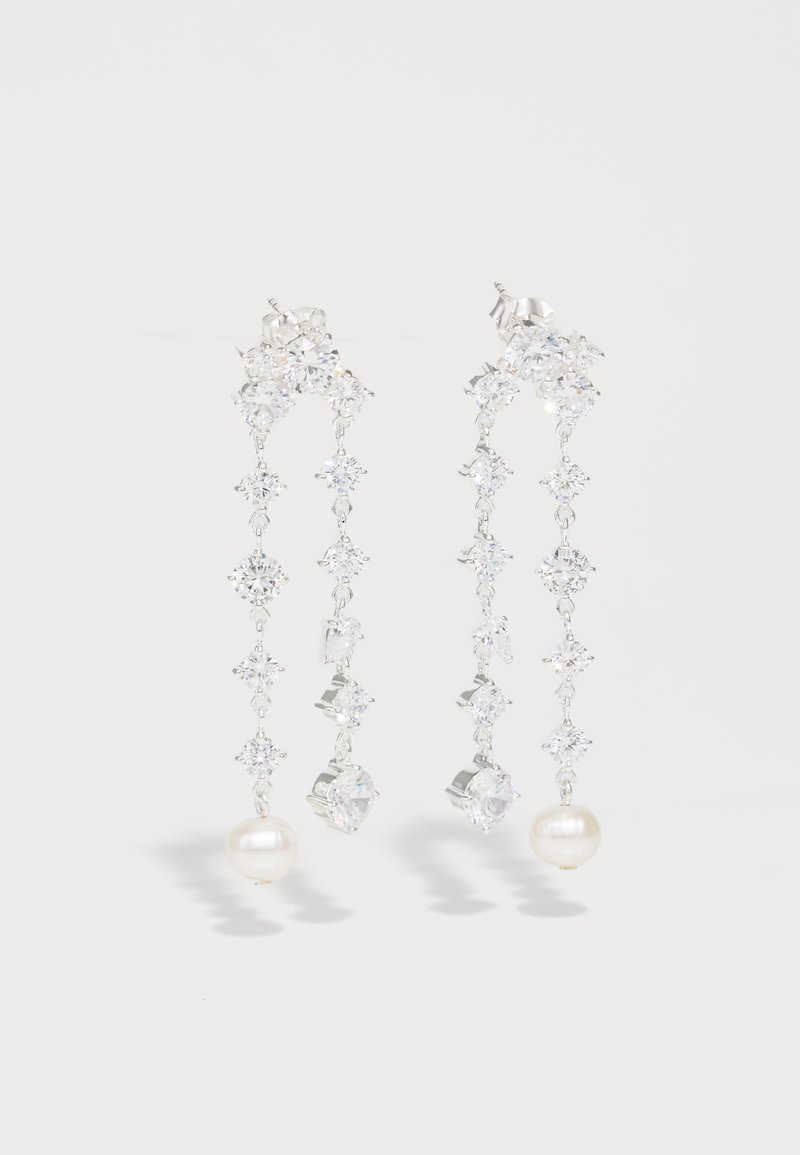 Ασημένια σκουλαρίκια με διακοσμητική σχεδίαση που έχει κρεμαστούς κρυστάλλους και περιπάτια μαργαριταριών, αντανακλώντας το φως με λεπτομερείς λεπτομέρειες.