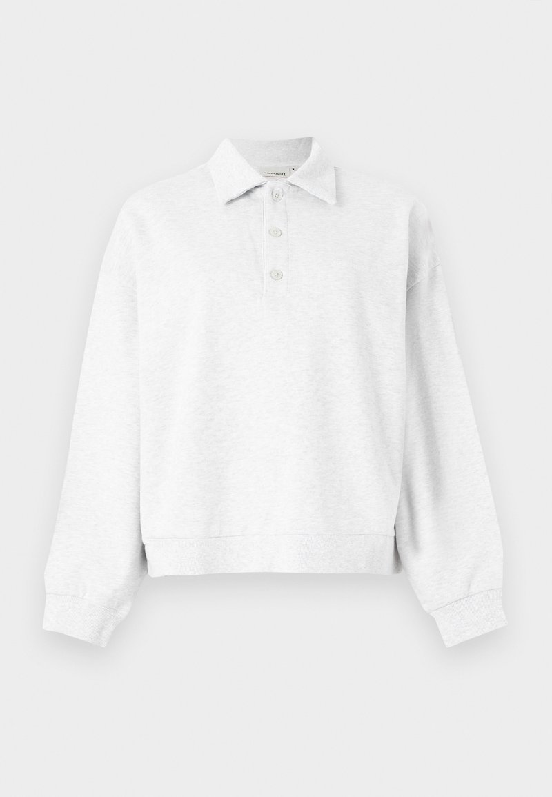 Jersey de manga larga color gris claro con cuello y tres botones en la tapeta, puños acanalados y un dobladillo ligeramente cropado.