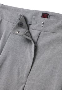 Grijze broek met een platte voorkant, ritssluiting en knoopsluiting. Gemaakt van textuurstof met een subtiel patroon. Rode en zwarte label zichtbaar.
