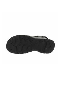 Suela de zapato deportivo negro que presenta una superficie de goma texturizada con patrones de relieve en zigzag para mayor agarre y tracción. Tacón redondeado y diseño flexible.