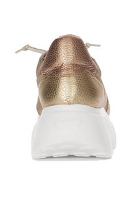 Zapatilla metálica dorada con parte superior de cuero texturizado, suela blanca y un diseño minimalista. Presenta una punta redondeada y cordones elásticos.