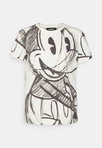 Hvid bomulds t-shirt med et sort skitseret design af en tegneseriefigur med store øjne og et smil. Standard rund hals og korte ærmer.