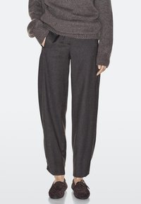 Gray wool trousers with a relaxed fit, featuring side pockets, subtle pleats, and accented by textured brown shoes.