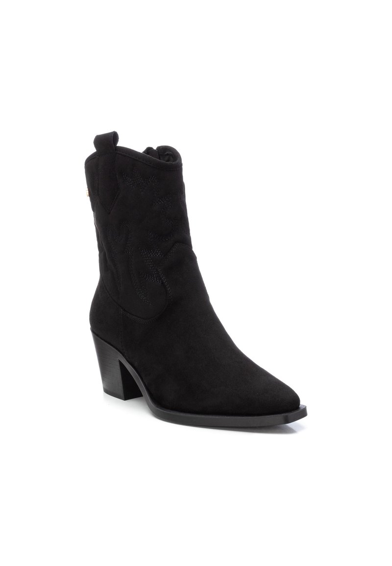 Botín de ante negro hasta el tobillo con puntera puntiaguda, tacón cuadrado y patrón de costura decorativa en la parte superior para textura y detalle.