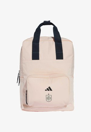 Sac à dos rose avec des accents noirs, comprenant deux poignées supérieures, une poche zippée à l'avant et le logo imprimé d'Adidas ainsi que les armoiries de l'Espagne.