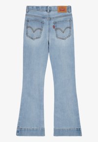 Ljusblå utsvängda jeans i denim, med en medelhög midja, två bakfickor med en distinkt sömdesign och en märkesläderlapp.