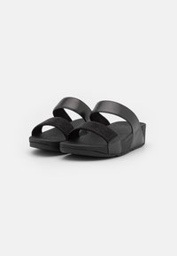 Zwarte sandalen met twee brede bandjes—één glad en één met textuur—bovenop een platte zool met een lichte verhoging bij de hak.