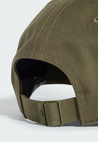 Olive green cap made of textured fabric with a curved peak, adjustable strap at the back, and reinforced stitching details.