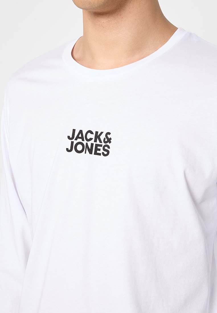 Maglietta bianca a maniche lunghe realizzata in cotone, con un logo nero "JACK & JONES" posizionato centralmente sul petto. Tessuto morbido.