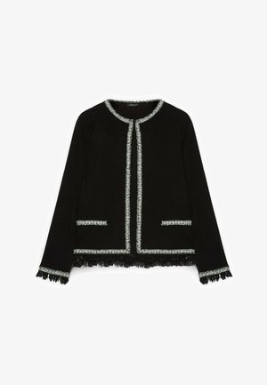 Schwarze Jacke mit texturiertem Fransensaum, silberner Verzierung entlang des Kragens und der Taschen sowie langen Ärmeln mit passenden Akzenten.