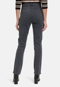 Szare dżinsy o prostym kroju i pięciu kieszeniach. Mają wysoki stan i delikatną fakturę. Noszone z czarnymi botkami na obcasie.