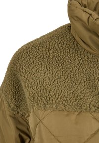Veste vert olive en tissu matelassé avec un panneau en laine texturée le long de l'épaule et du haut du dos.