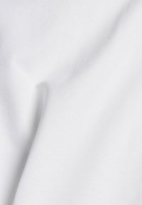White cotton fabric with a smooth texture, featuring subtle creases and folds, highlighting its soft drape and lightweight quality.