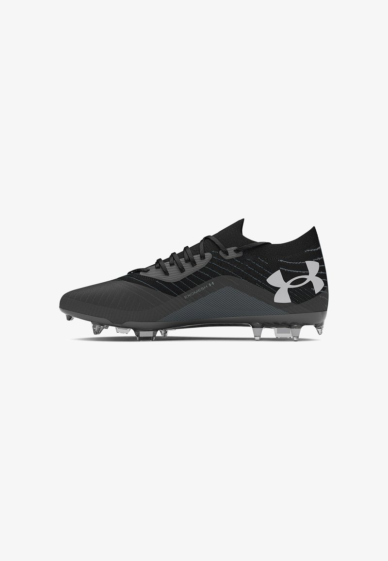 Crampon de football noir avec une tige synthétique texturée. Présente une semelle moulée, des crampons transparents et un logo Under Armour en argent.