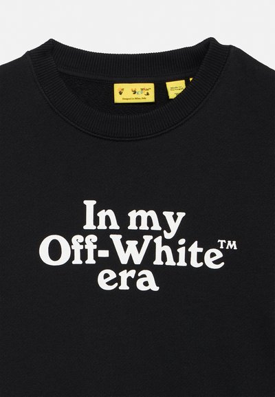 Черна суичър с бял текст с надпис "In my Off-White era" и жълти етикети за облекло вътре в яката.