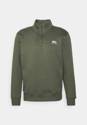 Olivgrüner Pullover mit hohem Kragen, Viertelreißverschluss, gerippten Manschetten und Bündchen; verfügt über ein weißes Logo auf der Brust.