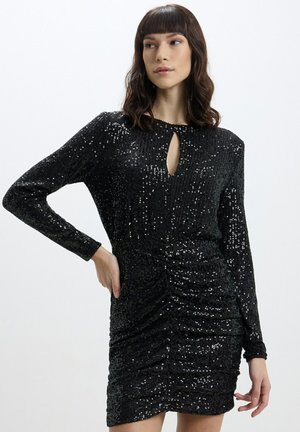 Abito nero in paillettes con maniche lunghe, dotato di scollatura a occhiello, superficie testurizzata e vestibilità aderente arricciata. Tessuto dalla trama liscia.