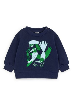 Sudadera para niño pequeño de color azul marino con ilustraciones abstractas de pájaros en verde y blanco y la palabra "picapica" en el frente.