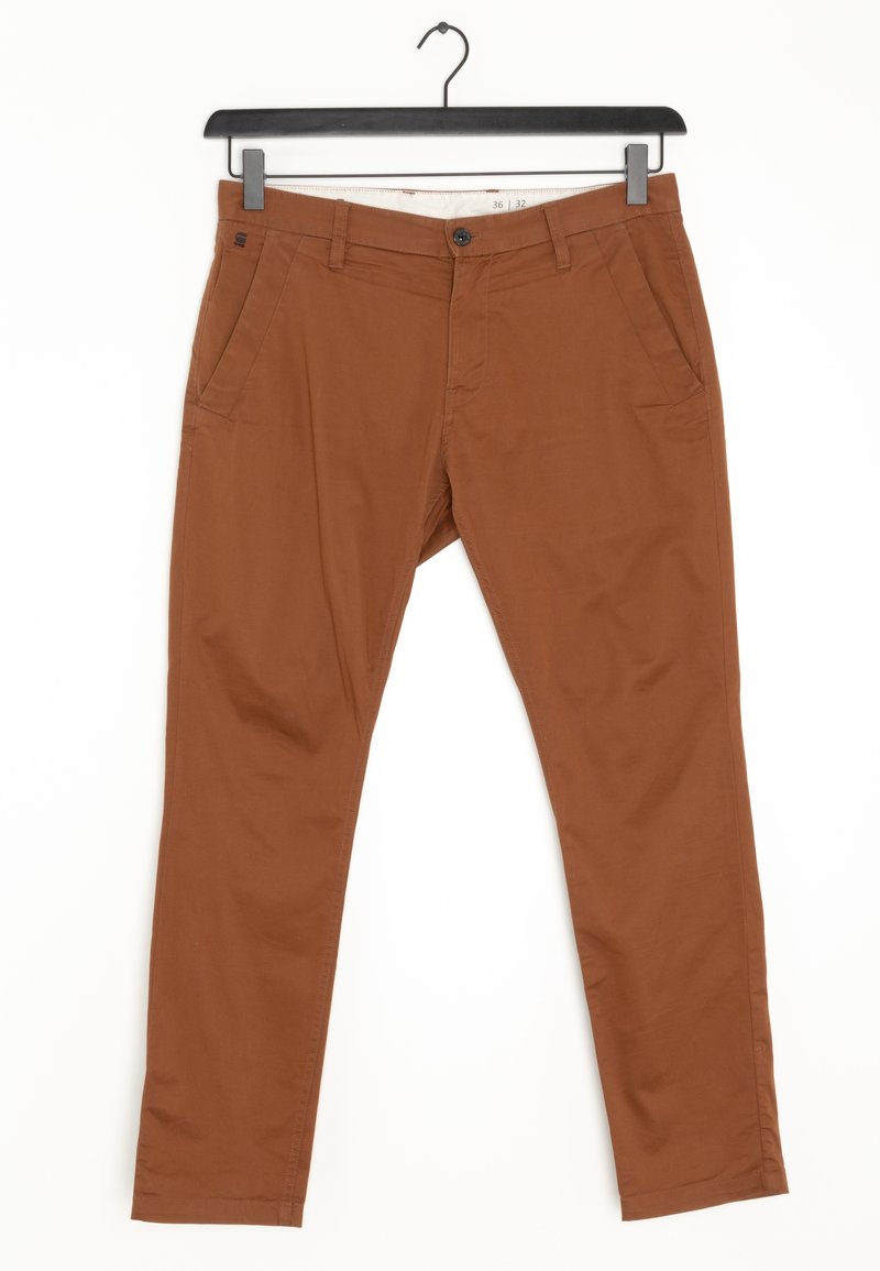 Pantalon marron slim avec poches avant, passants pour ceinture, fermeture à boutons, suspendu à un cintre noir sur fond blanc.