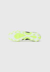 Black athletic shoe outsole with a bright yellow-green rubber segment, featuring circular traction patterns and white accents throughout.