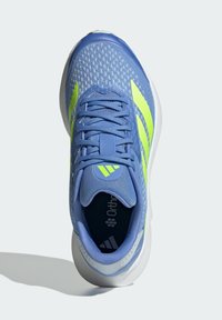 Blauwe sportieve schoen met een gestructureerde mesh bovenkant, accentueert door felgele strepen, een prominente logo en een dempende zool.