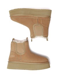 Beige Wildleder-Ankle Boots mit elastischen Seitenpaneelen, flauschigem Innenfutter und erhöhten Gummisohlen für Grip und Komfort.