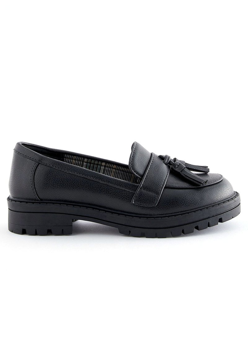 Mocassin en cuir noir avec un bout arrondi, doté d'un gland décoratif et d'une semelle en caoutchouc robuste à crampons. L'intérieur présente un motif à carreaux.
