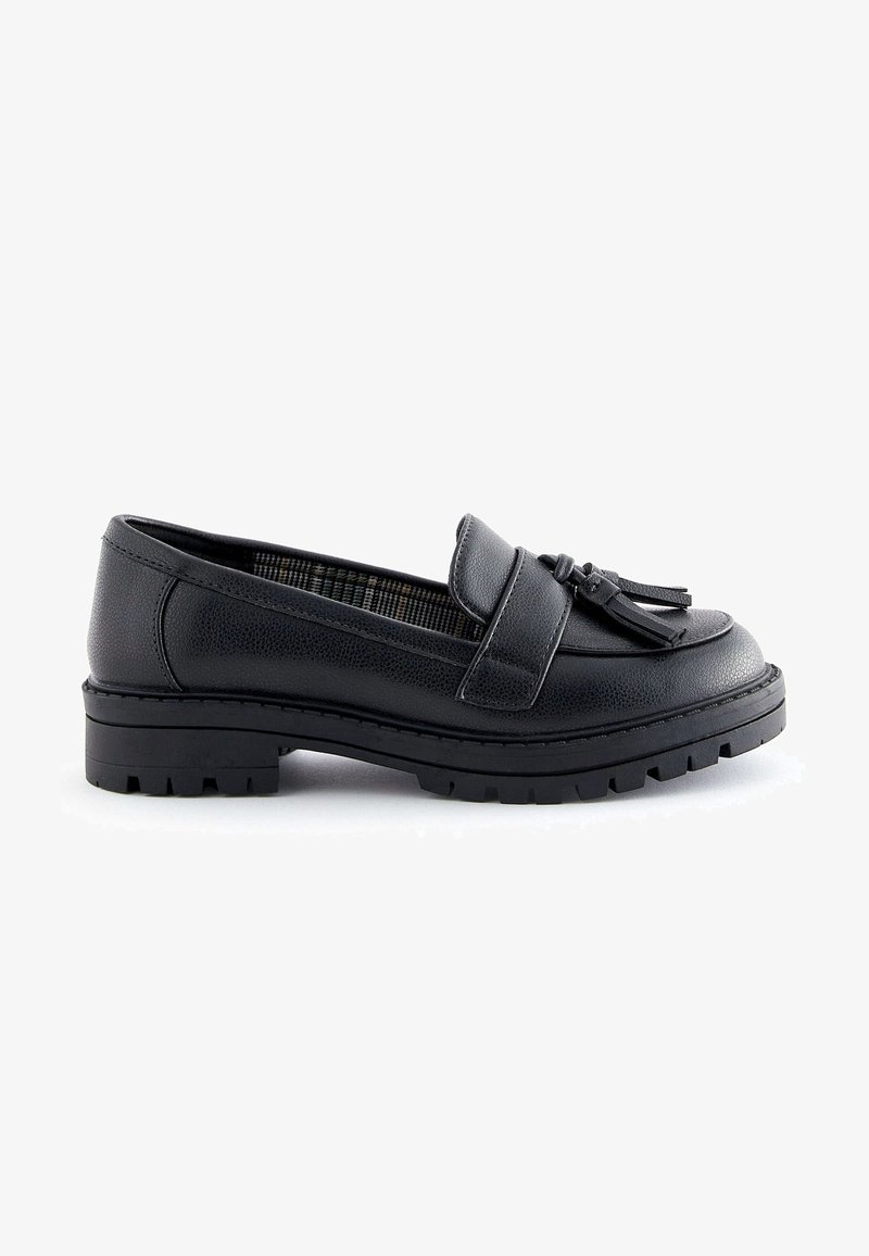 Mocassin en cuir noir avec un bout arrondi, doté d'un gland décoratif et d'une semelle en caoutchouc robuste à crampons. L'intérieur présente un motif à carreaux.
