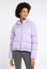 Puffjacka i ljuslila med ett sammetspanel högst upp, framsidans blixtlås och ribbade ärmslut. Mjuk, vadderad textur, designad för att hålla värmen.