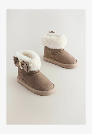 Pruunist sametist pahkluu saapad valge vale karvaneäärisega, ripskummist lindi kaunistus ühelt küljelt ja reljeefne kummitald haakumiseks.