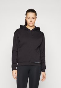 Sweat à capuche noir avec fermeture éclair, capuche à cordon de serrage, poches frontales et poignets côtelés. Présente une texture de tissu lisse avec un design minimaliste.