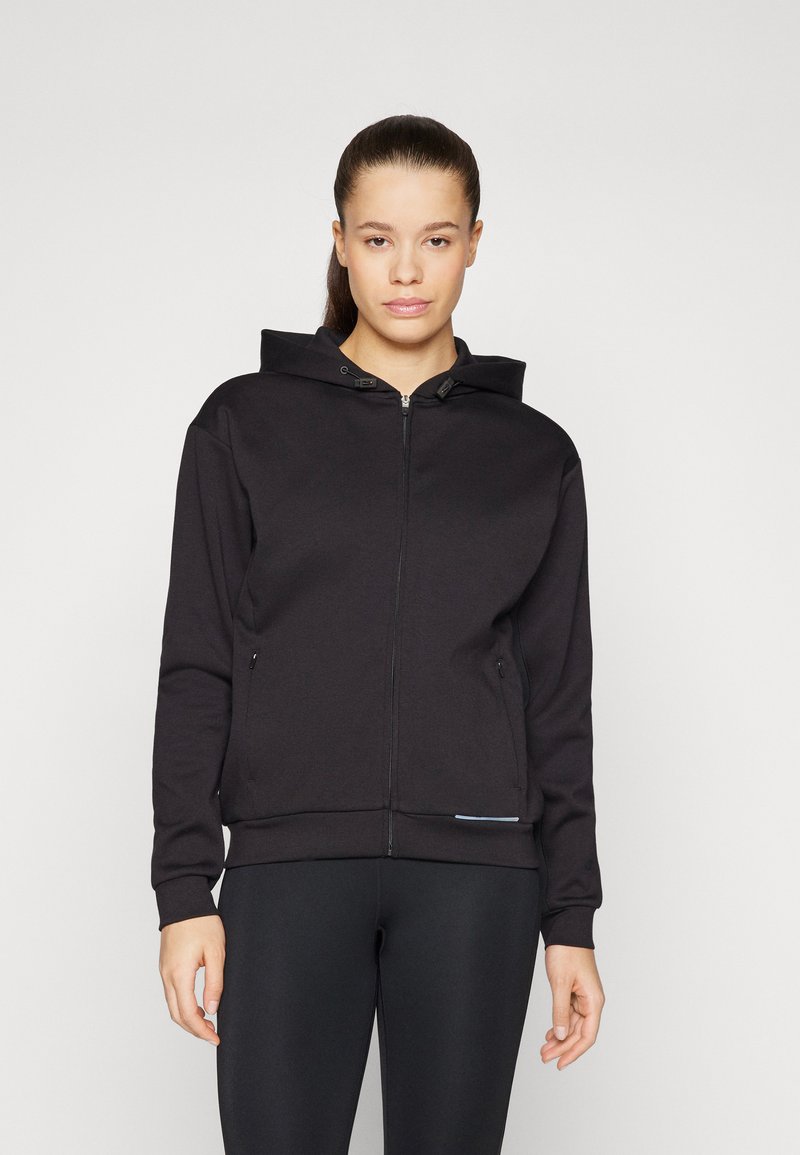 Sweat à capuche noir avec fermeture éclair, capuche à cordon de serrage, poches frontales et poignets côtelés. Présente une texture de tissu lisse avec un design minimaliste.