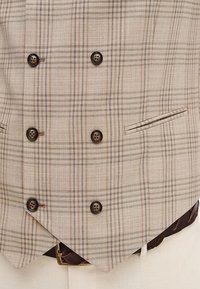 Beżowa kamizelka w kratę z teksturowanej tkaniny, z sześcioma ciemnymi guzikami i jedną boczną kieszenią, uzupełniona ciemno-brązowym skórzanym paskiem.