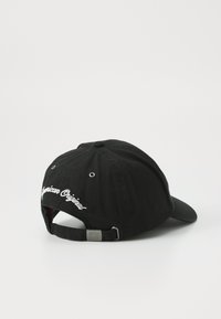 Casquette de baseball en coton noir avec une visière courbée, texte brodé "American Original" à l'arrière et une sangle ajustable en métal.