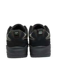 Baskets noires avec un dessus en suede et en maille, une semelle épaisse, et un design angulaire avec des accents texturés sur le talon et le détail du logo.