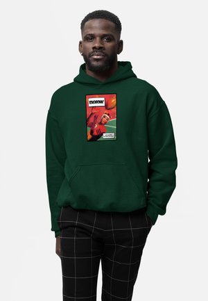 Mand iført mørkegrøn hættetrøje med en tegneseriestil grafik af en fodboldspiller, der griber en bold, og teksten "TOUCHDOWN!" foran.