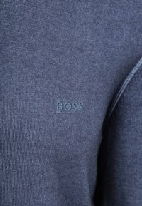 Marineblauer Strickpullover mit dezenter Rippstruktur und kleinem, gesticktem "BOSS"-Logo in passendem Farbton.
