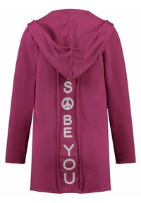 Tyrkysová mikina s kapucí, která má dlouhé rukávy a design na zádech s textem "SO BE YOU" vyrobeným ze stříbrných kamínků. Hladká, měkká tkanina.