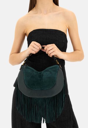 Borsa a mano verde in pelle con accenti in suede e lunghe frange. Forma arrotondata, manico corto, finitura testurizzata. Nessun dettaglio hardware visibile.