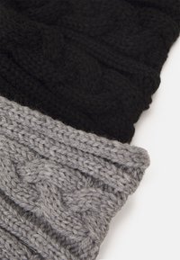 Black and gray knitted beanies featuring a textured cable pattern, with a thick ribbed hem for added warmth and style.