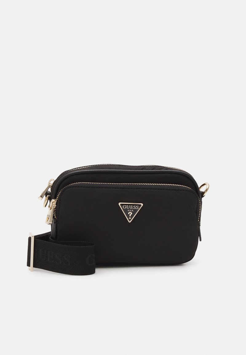 Svart nylon crossover-veske med et gull trekantet logo, glidelås og en bred justerbar stropp med ordet "GUESS" i svart.