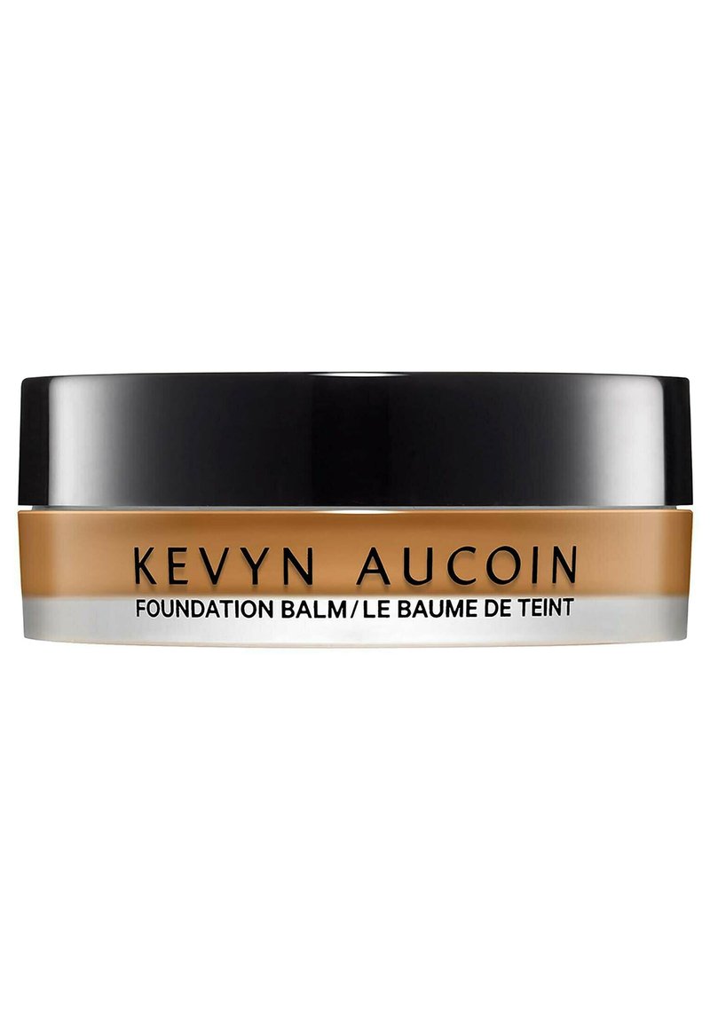 Kevyn Aucoin foundation balm in a round, black and clear container. Creamy texture; golden-brown color; text on the label in black.