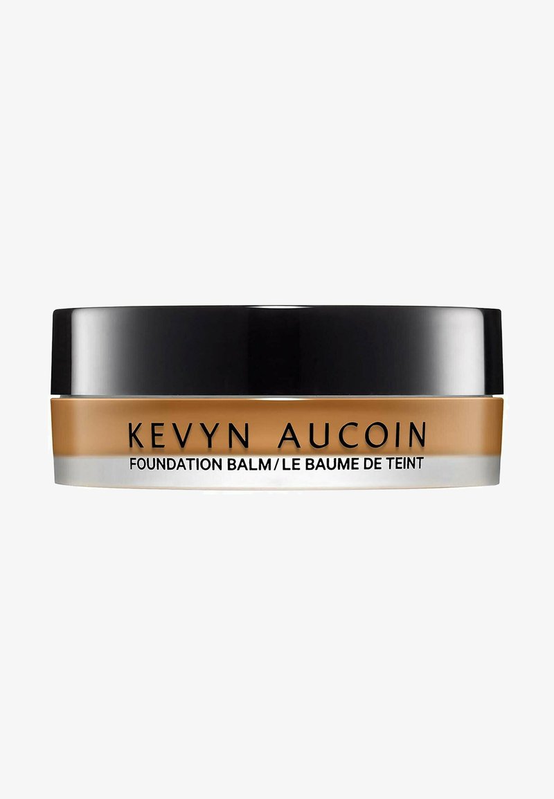 Kevyn Aucoin foundation balm in a round, black and clear container. Creamy texture; golden-brown color; text on the label in black.