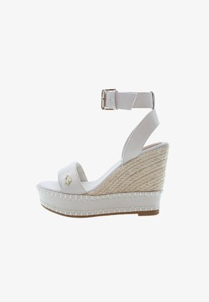 Białe sandały na koturnie z teksturowanym, jutowym obcasem, z zamkniętym paskiem na palcach, regulowanym paskiem wokół kostki oraz złotym akcentem. Gładkie wykończenie z tkaniny.
