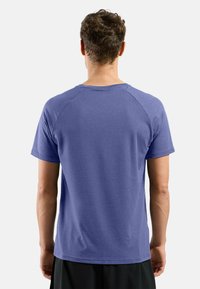 Purple short-sleeve t-shirt with a rounded neck, made of soft fabric. Features raglan sleeves and a relaxed fit with no visible patterns.