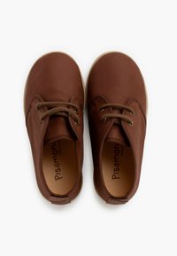 Zapatos de cuero marrón con punta redondeada y diseño de cordones. Presentan una superficie texturizada y una suela de goma de color claro.