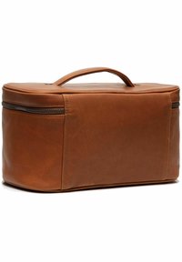 Bolsa de viaje rectangular de cuero marrón con un asa, cierre de cremallera y detalles de costura visibles. Textura suave con un diseño minimalista.