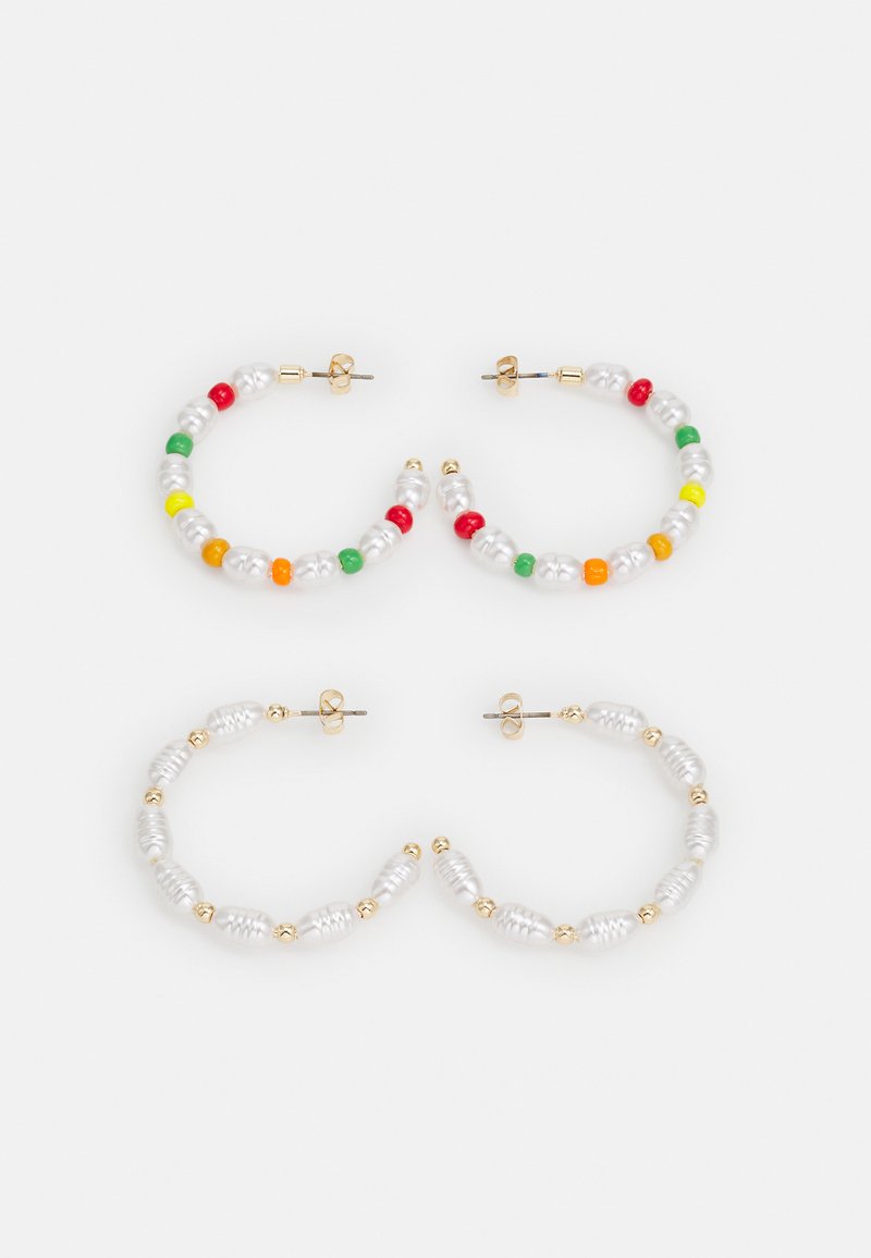 Três pares de brincos em argola: dois com contas multicoloridas e um com contas brancas brilhantes e detalhes em ouro, com uma forma arredondada.