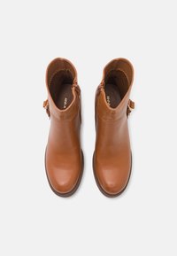 Brązowe skórzane botki na kostkę o gładkim wykończeniu, z teksturowanym górnym panelem, zamkiem błyskawicznym i ozdobnym paskiem z boku.