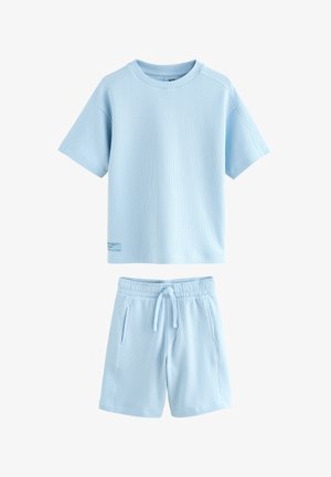Svijetloplava majica kratkih rukava od tkanine u obliku vafla i odgovarajući kratki hlače s vrpcom za vezanje i bočnim džepovima.
